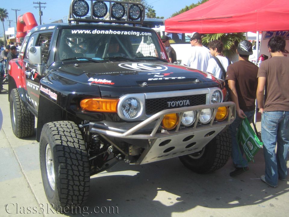 Black Toyota FJ Cruiser prerunner with roof lights and tube bumper at an outdoor event