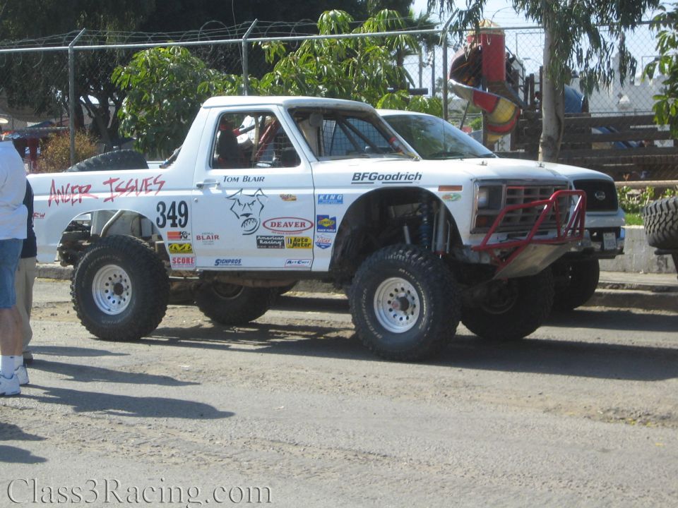 White Ford race truck 349 Anger Issues with red roll cage and large off-road tires