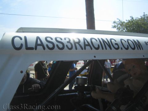 1990 Ford Bronco - Close-up of a white race vehicle roof stenciled 'CLASS3RACING.COM' with a tube-frame interior and an inflatable doll visible inside.