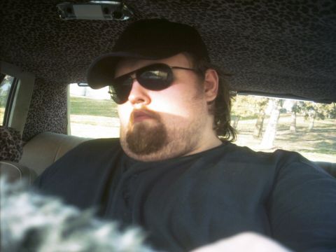 1985 Ford Crown Victoria LTD - A man with a beard and sunglasses is inside a vehicle with a distinctive leopard print headliner and door panels.