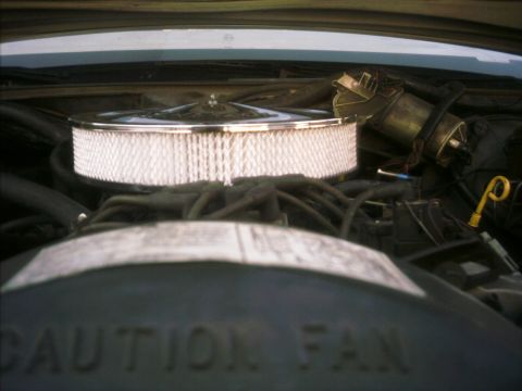 1985 Ford Crown Victoria LTD - Close-up view of an engine bay, a chrome-plated air cleaner assembly and visible warning text.
