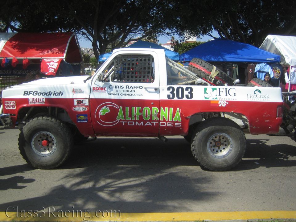 Side profile of red and white number 303 California Tomatoes race truck