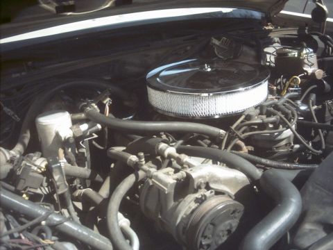 1985 Ford Crown Victoria LTD - Close-up view of an engine bay, a chrome air filter and various engine parts.