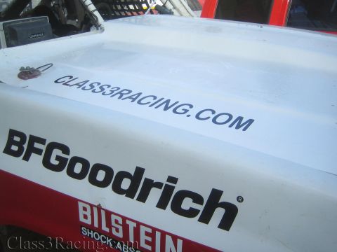 1990 Ford Bronco - Close-up of a white race truck hood bearing BFGoodrich, Bilstein and Class3Racing.com lettering.