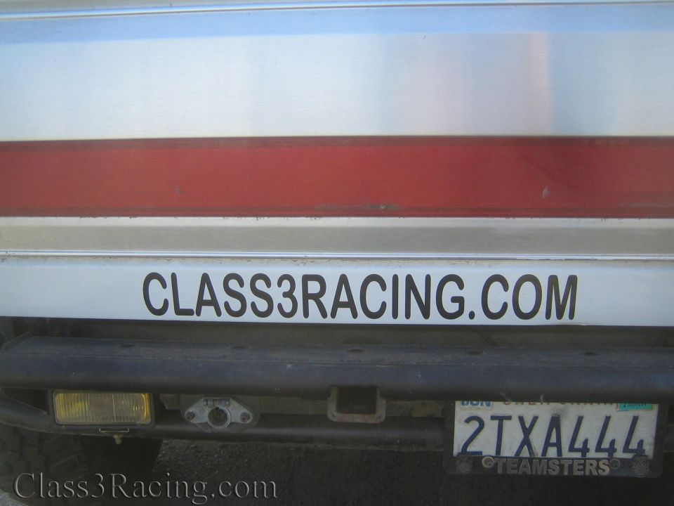 Tailgate of white truck with red stripe, Class3Racing.com decal and California plate 2TXA444