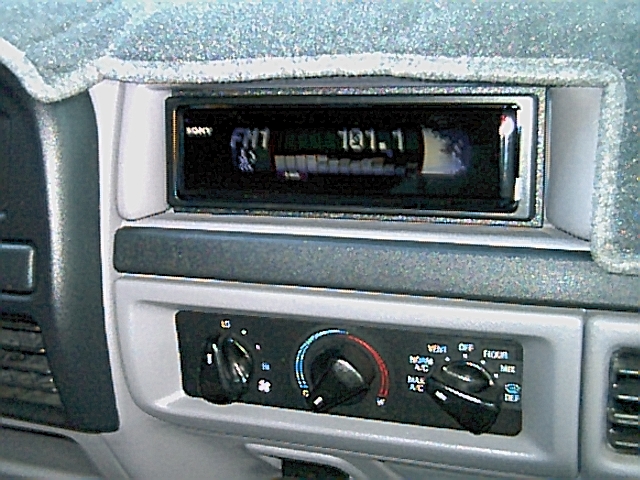 Sony aftermarket radio showing FM 101.1 above factory HVAC knobs in a gray Ford dash