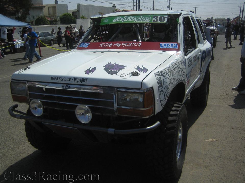 White lifted SUV race truck number 30 with Ford grille and two front driving lights