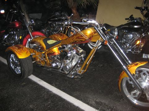 1986 Ford Bronco - A custom trike motorcycle with elaborate flame graphics is parked alongside other motorcycles.
