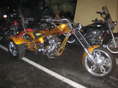 1986 Ford Bronco - A custom trike motorcycle with elaborate flame paintwork is parked alongside other motorcycles.