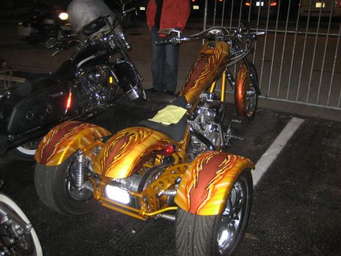 1986 Ford Bronco - Custom trike motorcycle with flame paint job is parked next to another motorcycle.