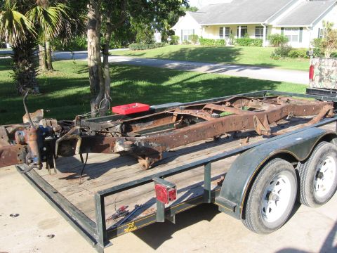 1974 Ford F-100 - A heavily rusted truck frame is loaded onto a trailer, ready for transport or restoration.