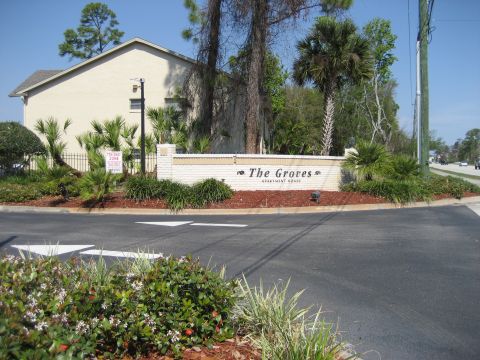 1986 Ford Bronco - Entrance sign for The Groves Apartment Homes with landscaping and a building in the background.