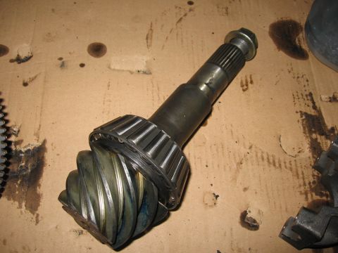 1974 Ford F-100 - A differential pinion gear and bearing assembly is shown, resting on a surface marked with oil stains.