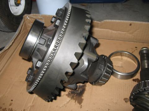 1974 Ford F-100 - Close-up of a differential assembly with gears and bearings, resting on cardboard.