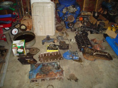 1976 Ford F-100 - Various engine components are laid out on the floor of a garage.