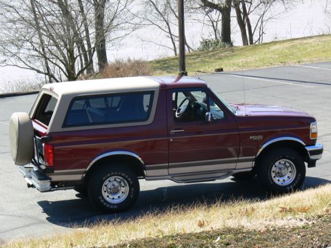 1996 Ford Bronco - This 1996 Ford Bronco is shown in a three-quarter front view, a maroon body with a tan removable top and a spare tire mounted on the rear.