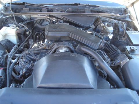 1992 Ford Crown Victoria - The engine bay of a 1992 Ford Crown Victoria reveals its V8 engine configuration with visible air intake and wiring.