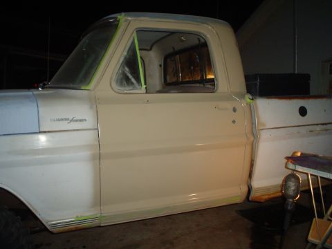 1967 Ford F-250 - This 1967 Ford F-250 shows its side profile, with the cab painted beige and the fender in blue, suggesting a work in progress.