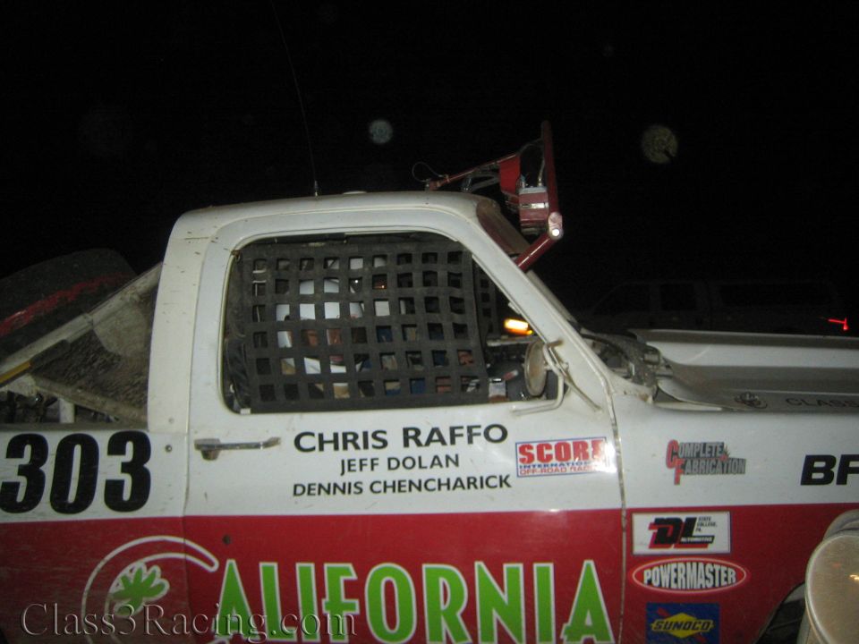 White race truck 303 with window net and Chris Raffo team names at night
