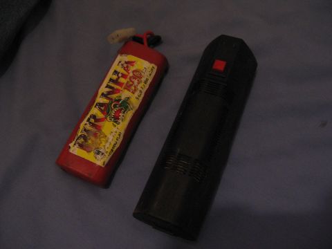 1974 Ford F-100 - Two toy items, one red with a Piranha 500 label and the other black with a red button, are shown on a blue surface.