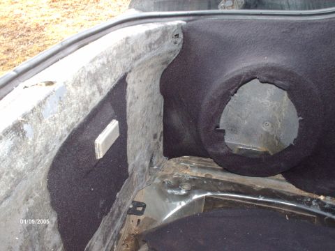 1995 Ford Probe - Close-up view of the inside of a car's trunk, revealing carpeting and a speaker cutout.
