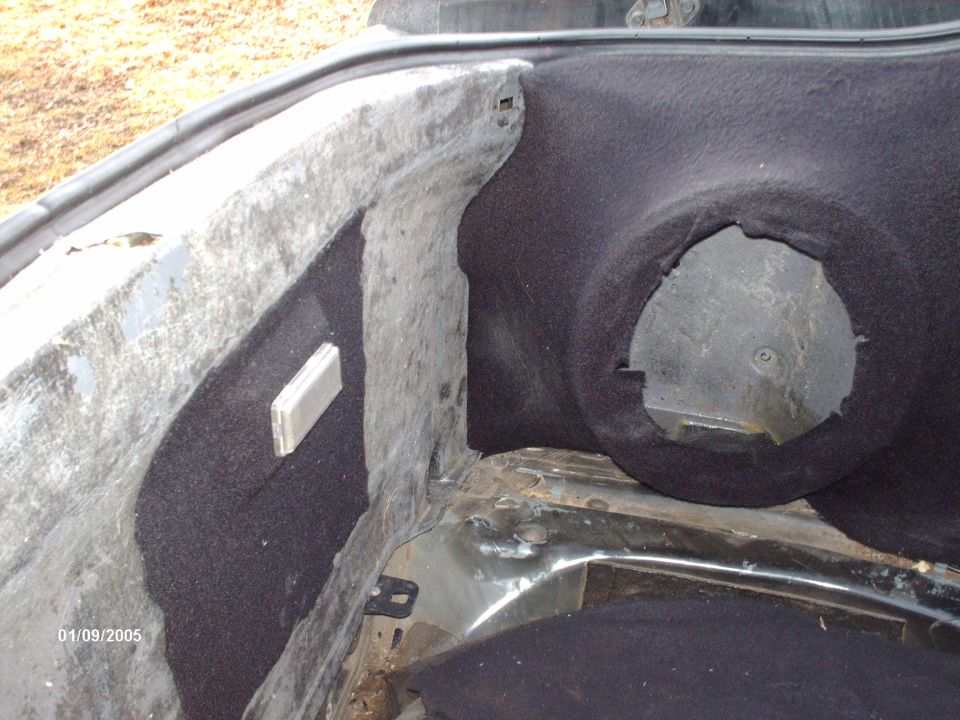 Interior of a car trunk showing carpeting and a circular cutout. Date stamp reads 01/09/2005