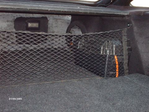 1995 Ford Probe - A cargo net secures items in the trunk of a vehicle, with a storage box and orange handle visible.