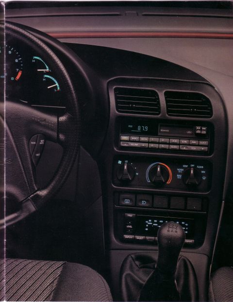 1993 Ford Probe - The interior of a car is shown, the dashboard, steering wheel, and center console with radio and climate controls.