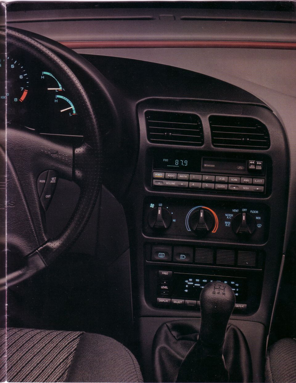 Car interior showing steering wheel, dashboard, radio, and gear shift