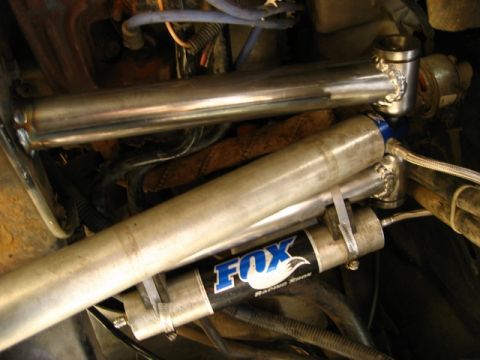 1989 Ford Bronco - Close-up of engine bay components, Fox Racing shocks and custom metal tubing.