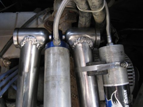 1989 Ford Bronco - Close-up of engine bay components, including shock absorbers and braided hoses.