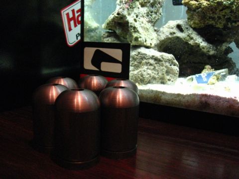 1989 Ford Bronco - Metal parts are arranged on a table in front of a partially visible aquarium with rocks and sand.