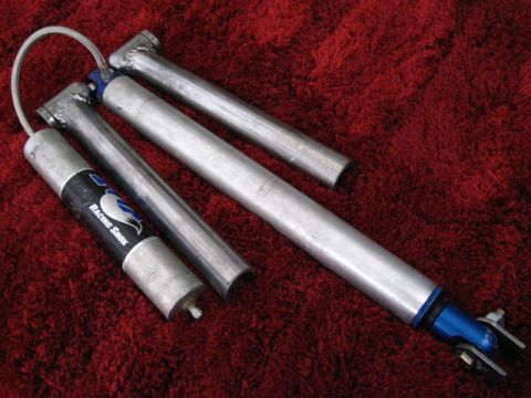 1989 Ford Bronco - Close-up view of two racing shocks, one with a black label indicating 'Racing Shox'.