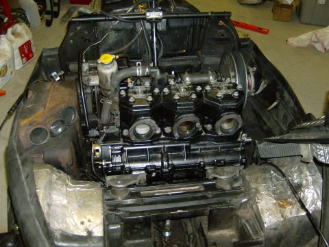 1982 Chevrolet C/K Pickup - Close-up of a snowmobile's three-cylinder engine during maintenance or repair.