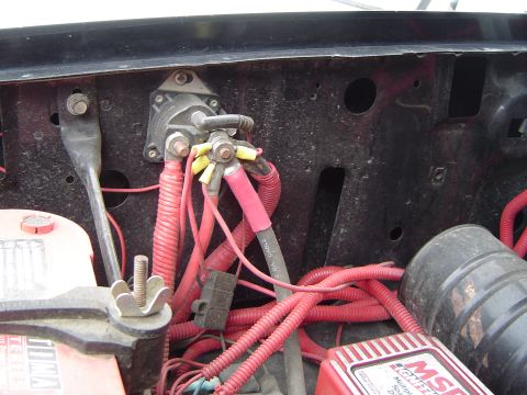 1989 Ford Bronco - Close-up view of the engine bay wiring, showing a battery, solenoid, and ignition system components.