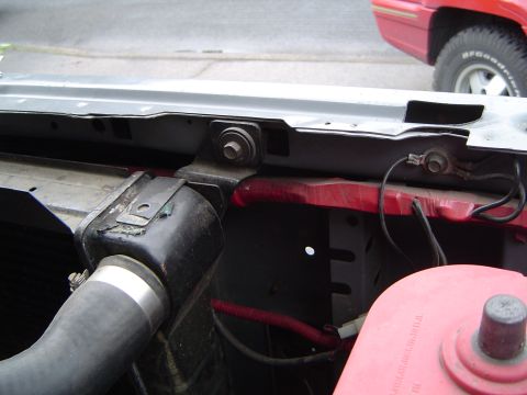 1989 Ford Bronco - Radiator support bracket and hose detail, with another vehicle visible in the background.