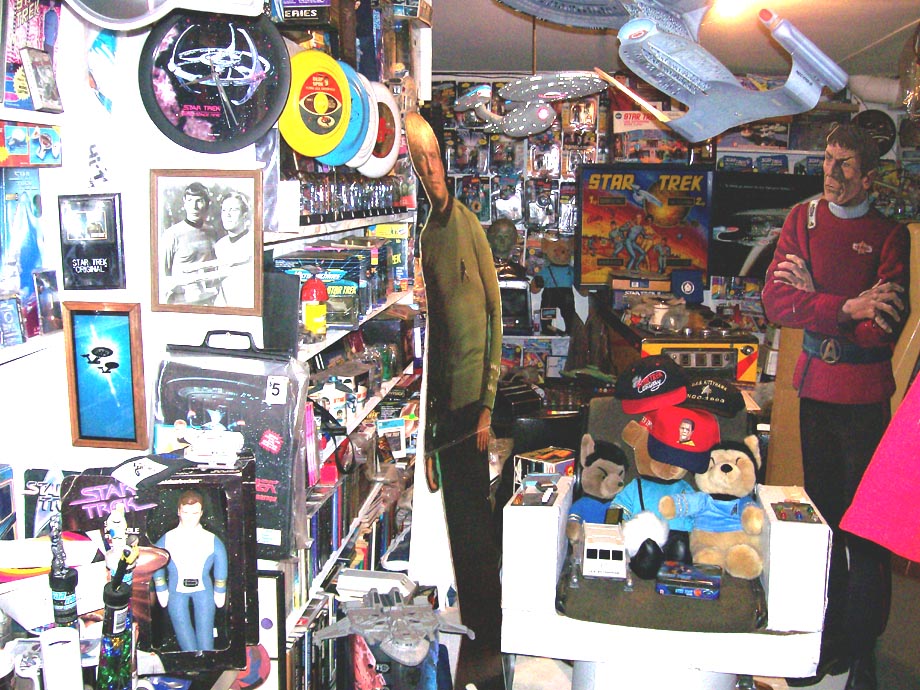 Room filled with Star Trek toys, models, and figures including Spock and a cardboard cutout