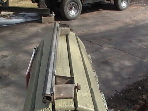 1990 Ford Bronco - Weathered wooden structure with metal hardware, with a vehicle tire visible in the background.