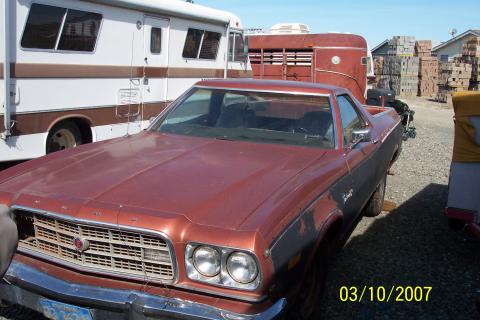 1973 Ford Ranchero - A red 1972 Ford Ranchero is parked next to an RV and other vehicles in a lot.