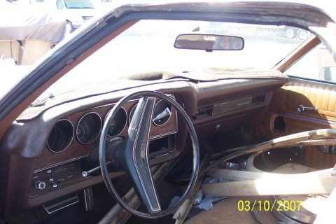 1973 Ford Ranchero - The interior of a 1973 Ford Ranchero Squire shows its age with worn upholstery and a cluttered passenger side.