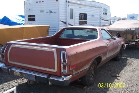 1973 Ford Ranchero - Rear view of a red 1973 Ford Ranchero Squire pickup truck, showing its distinctive tailgate paneling.