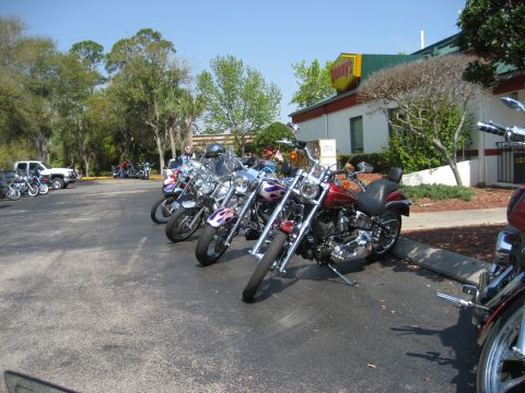 1986 Ford Bronco - Several motorcycles are parked in a lot in front of a Denny's restaurant on a sunny day.