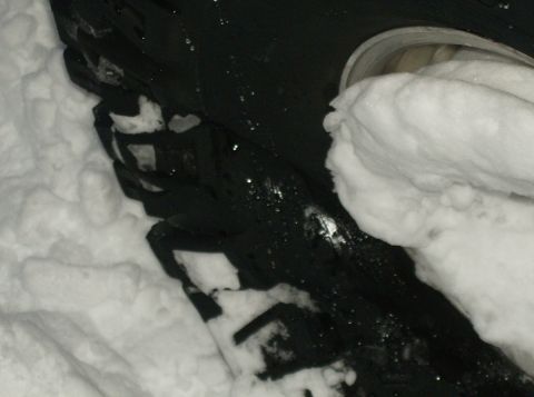 1986 Ford Bronco - A tire is seen stuck in the snow, with some of the tread pattern visible.