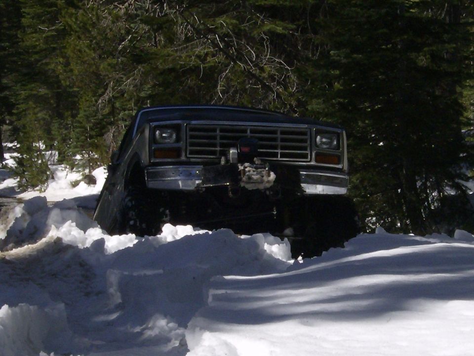 Dark 1980s Ford Bronco with winch in snow