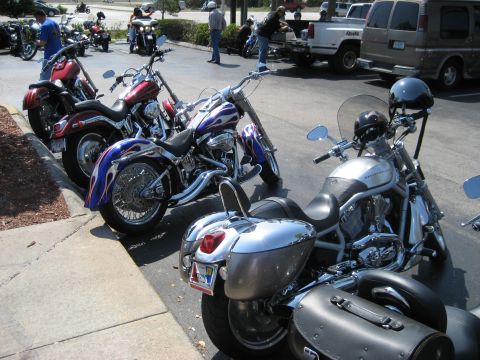 1986 Ford Bronco - A collection of custom motorcycles are parked in a lot on a sunny day.