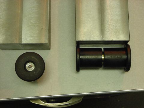 1994 Ford Bronco - Close-up of suspension bushings and related parts on a metallic surface.