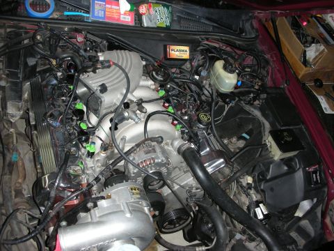 1992 Ford Crown Victoria - The engine bay is filled with a supercharger, numerous hoses, and electrical wiring, suggesting modifications or repairs.