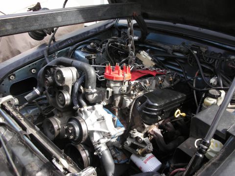 1990 Ford Mustang - Engine bay with engine hoist, showing a V8 engine with red distributor cap and a Ford oil filter.