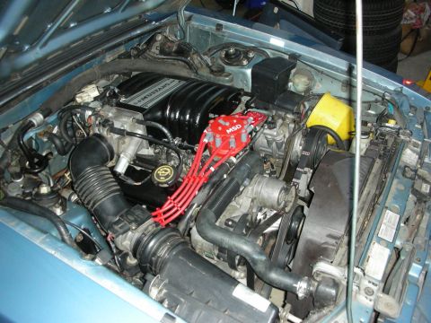 1990 Ford Mustang - Close-up view of the engine bay in a 1990 Ford Mustang, highlighting the intake manifold and ignition system.