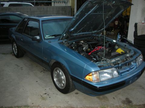 1990 Ford Mustang - Blue 1990 Ford Mustang coupe with its hood open, parked outdoors.